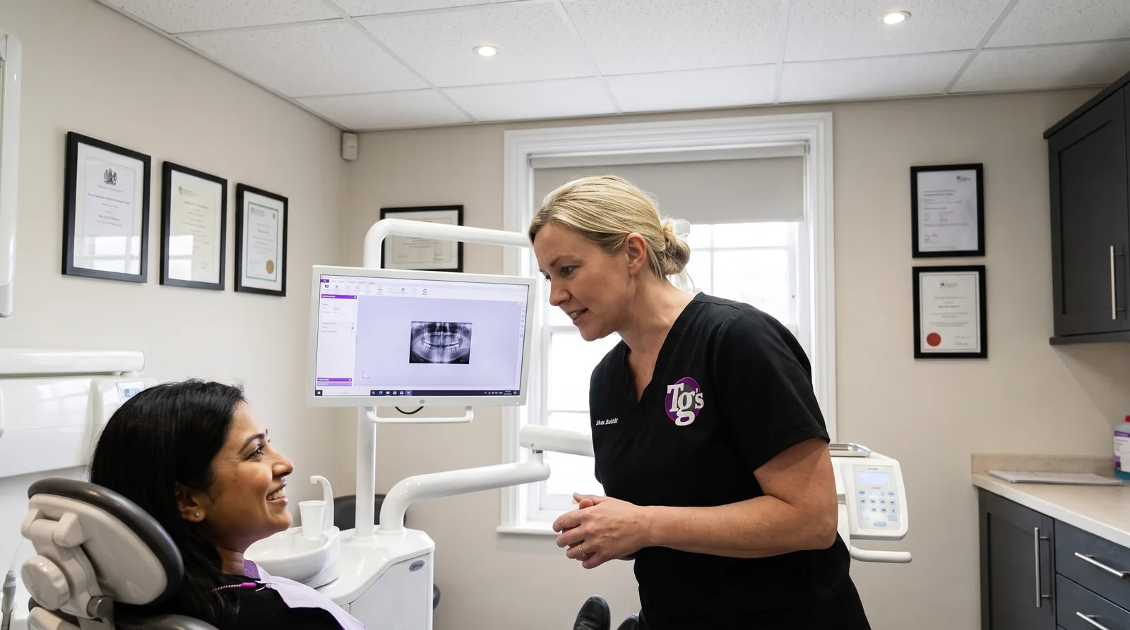 Dentist showing a patient their dental scan on a chairside screen during a new patient examination