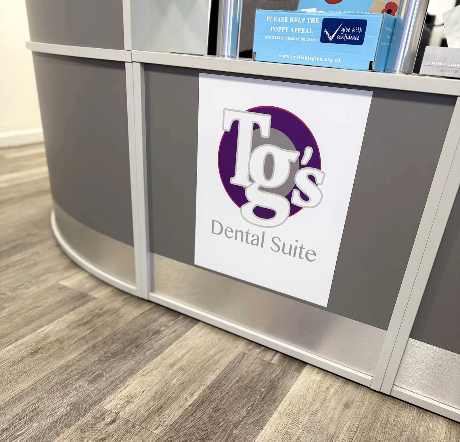 Reception desk at Earls Barton, carrying the TG's Dental Suite roundel panel