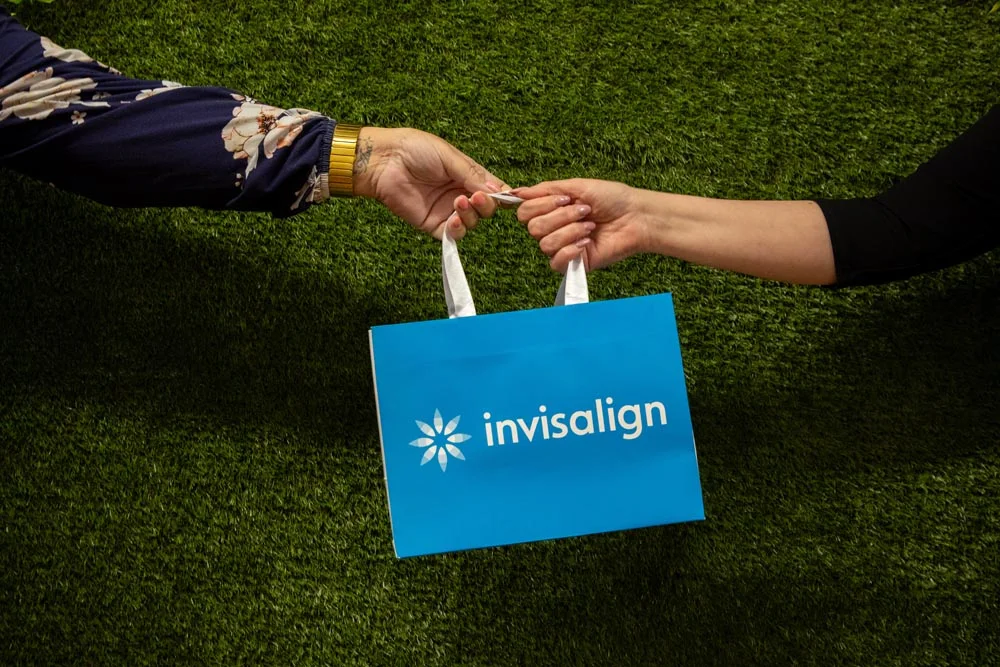 A TG's Dental Suite team member handing over an Invisalign bag
